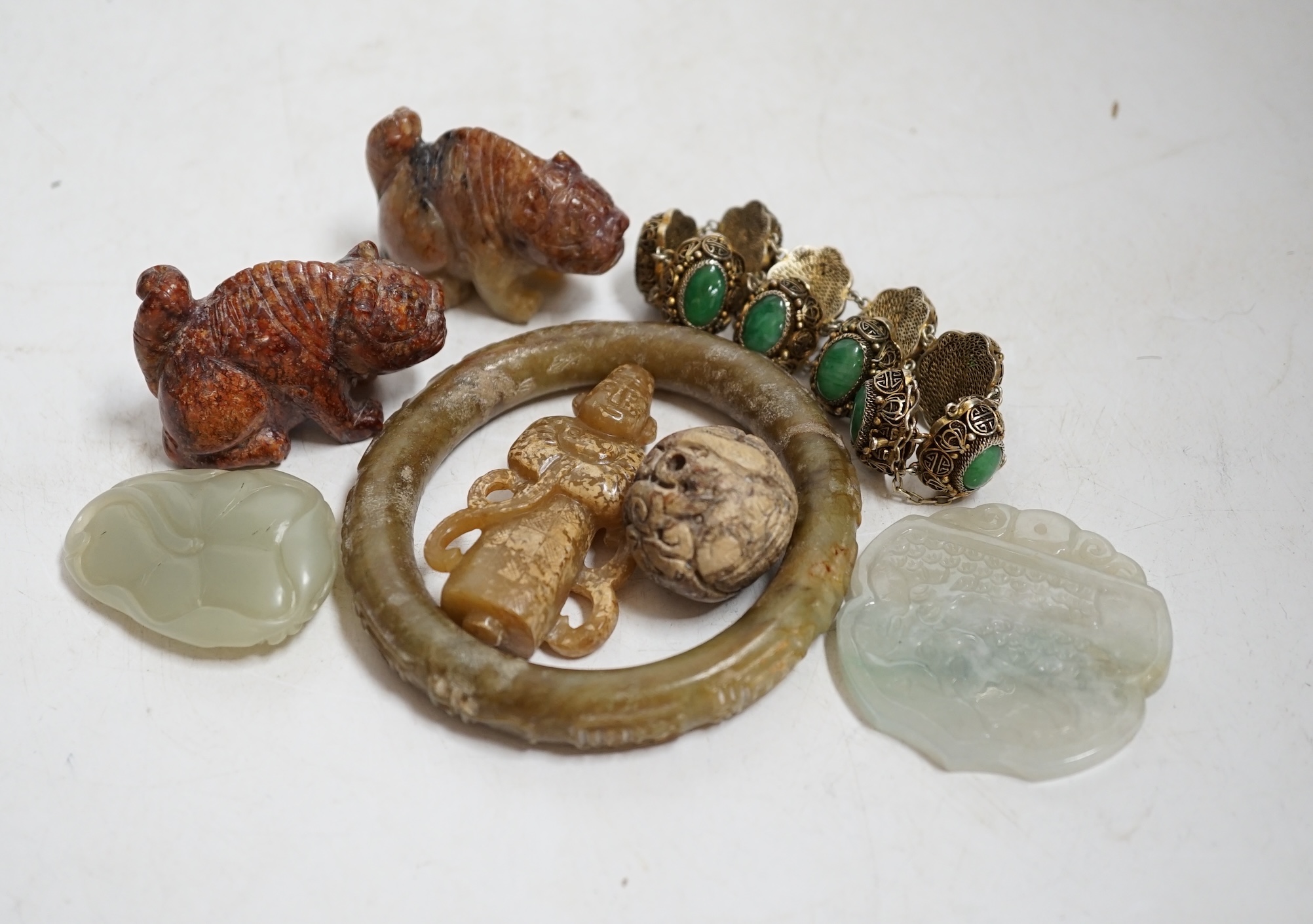 Sixteen Chinese jade and hardstone carvings, including a gilded white metal and jadeite bracelet, three pendants etc. Condition - fair